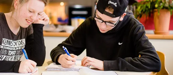 Zwei Jugendliche im Förderzentrum Altdorf lernen am Schreibtisch