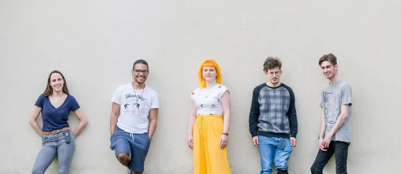 Auszubildende des Bundesbildungswerk Rummelsberg stehen nebeneinander vor einer Wand