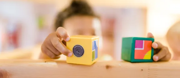 Kind spielt mit Bauklötzen in der Kinderkrippe