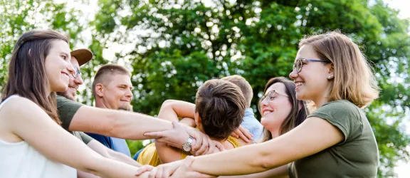 Eine Gruppe von Menschen, die eine Person hochheben