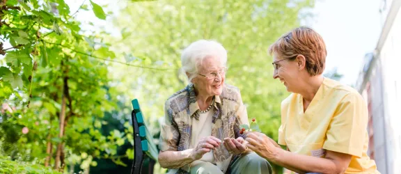 Seniorin mit Pflegefachkraft im  Garten