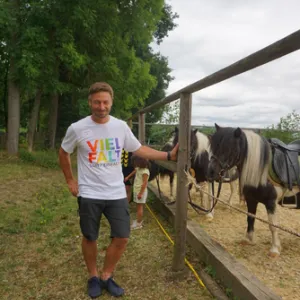 Mann steht vor Pferdekoppel