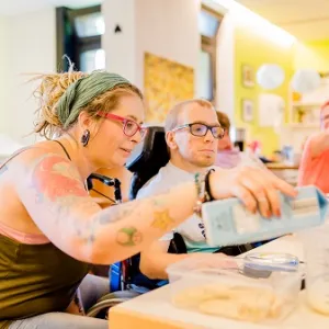 Die Lehrkraft führt mit einem Schüler der Berufsschulstufe ein Experiment durch