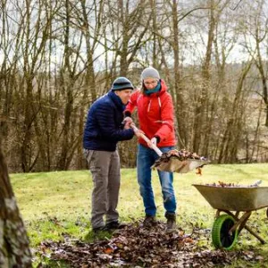 Zwei Menschen halten eine Schaufel