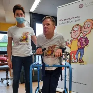 Ein Pfleger und ein Mann mit Rollator