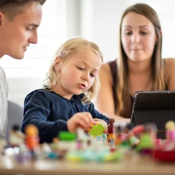 Kind mit Lernenden am Tablet