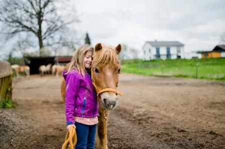 Mädchen umarmt Pferd