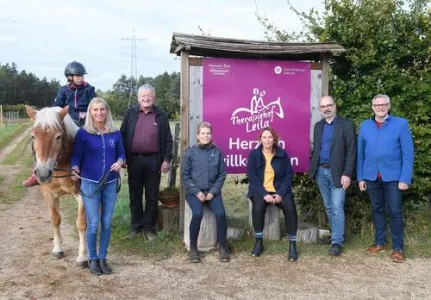 Sieben Menschen vor dem Schild Therapiehof Leila