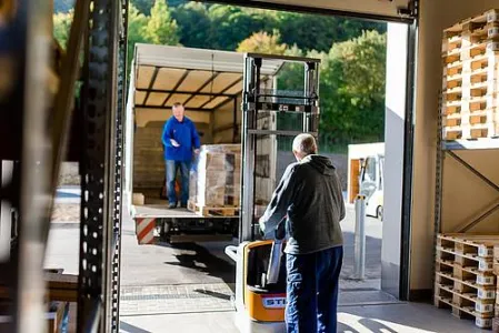Eine Person belädt einen LKW