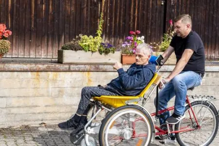 Mitarbeiter fährt Beschäftigten gemeinsam Fahrrad