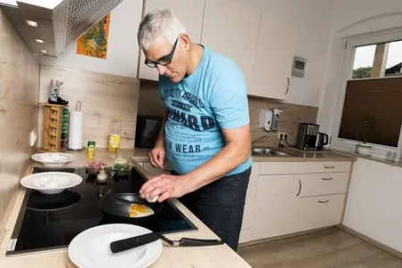 Ein Mann kocht in der Küche am Herd