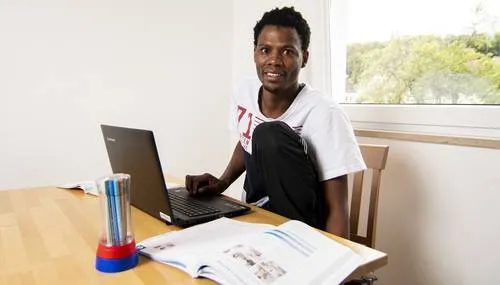 Ein Mann sitzt am Tisch mit einem Laptop