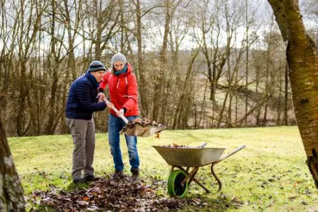 Zwei Menschen halten eine Schaufel