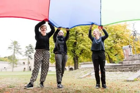 Drei Frauen halten Tuch in die Höhe