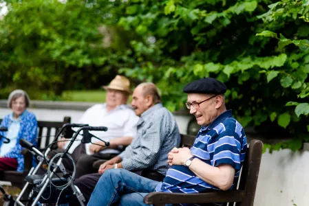 Vier alte Menschen sitzen draußen 