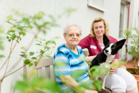 Seniorin auf Bank mit Hund