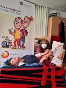 Eine Pflergerin und eine Person auf einer Liege