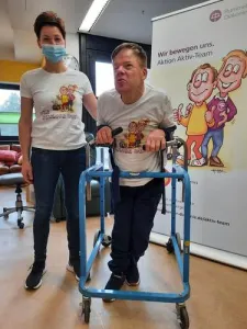 Ein Pfleger und ein Mann mit Rollator