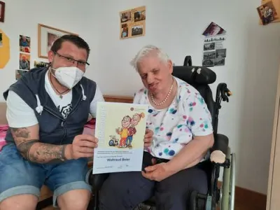 Pfleger mit Frau im Rollstuhl