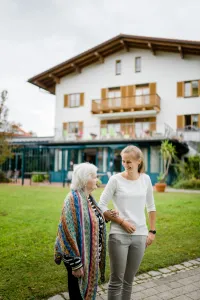 Seniorin und Besucherin vor Parkwohnanlage