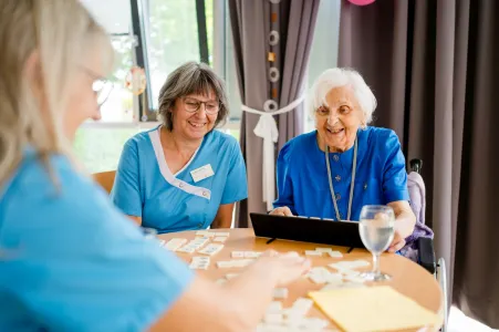Betreuungsfachkraft und Seniorin beim Spielen