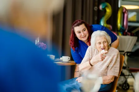 Seniorin und Pflegefachkraft freuen sich