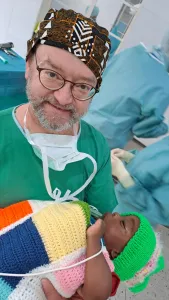Dr. Klaus Schwendner mit schlafendem Kind des Projekt Feuerkinder