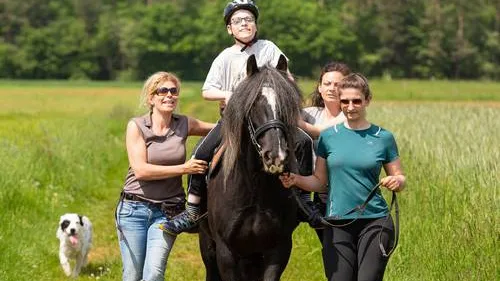 Kind sitzt auf Pferd.