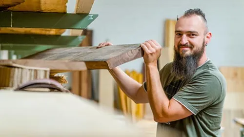 Schreiner sucht Holzplatte in der Schreinerei aus