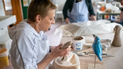 Eine Frau formt einen Vogel aus Ton
