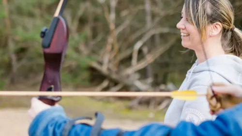 Jugendliche mit Therapeutin  beim Bogenschießen