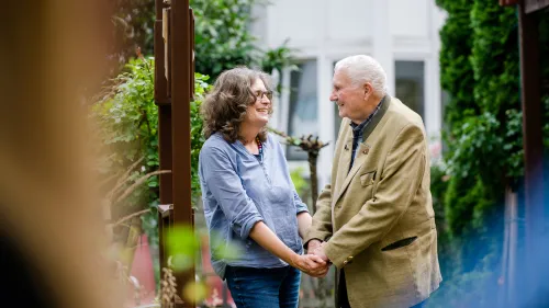 Eine Frau und ein Mann greifen sich an den Händen.