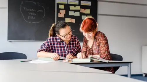 Zwei Auszubildende in der Pflege lernen gemeinsam