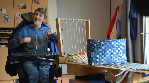 Ein Mitarbeiter am Webstuhl in der Förderstätte. Hier entstehen handgefertigte Produkte für den Verkauf.