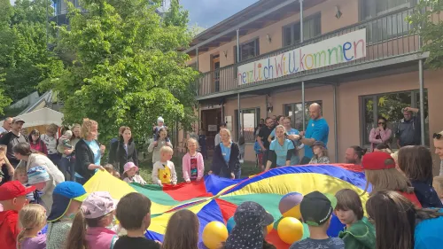 Eröffnung mit dem Schwungtuch: Das „Fest der Fröhlichen Farben“ – die Mitarbeiter*innen der Frühförderstelle begrüßen ihre großen und kleinen Gäste so farbenfroh, wie der Name es vermuten ließ. 