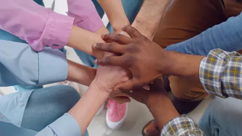 Viele Hände, die sich in der Mitte berühren.