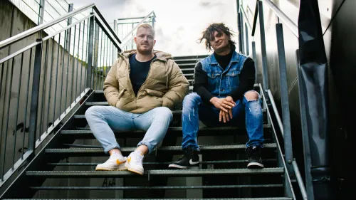 Das Bild zeigt zwei junge Menschen die auf einer Treppe sitzen.