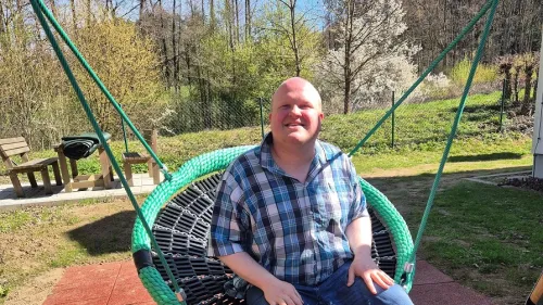 Hannes freut sich über die neue Schaukel im Garten des Wohnbereichs für Menschen im Autismus-Spektrum der Rummelsberger Diakonie in Hersbruck. 